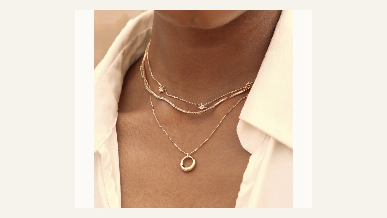 Astrid and Miyu Cosmic Star necklace worn in a layered gold jewellery stack